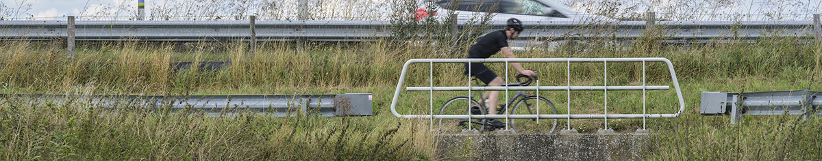 Racefietser met auto op achtergrond